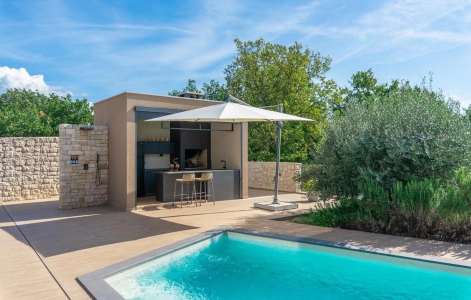 Letná kuchyňa s barom pri bazéne a slnečníkom