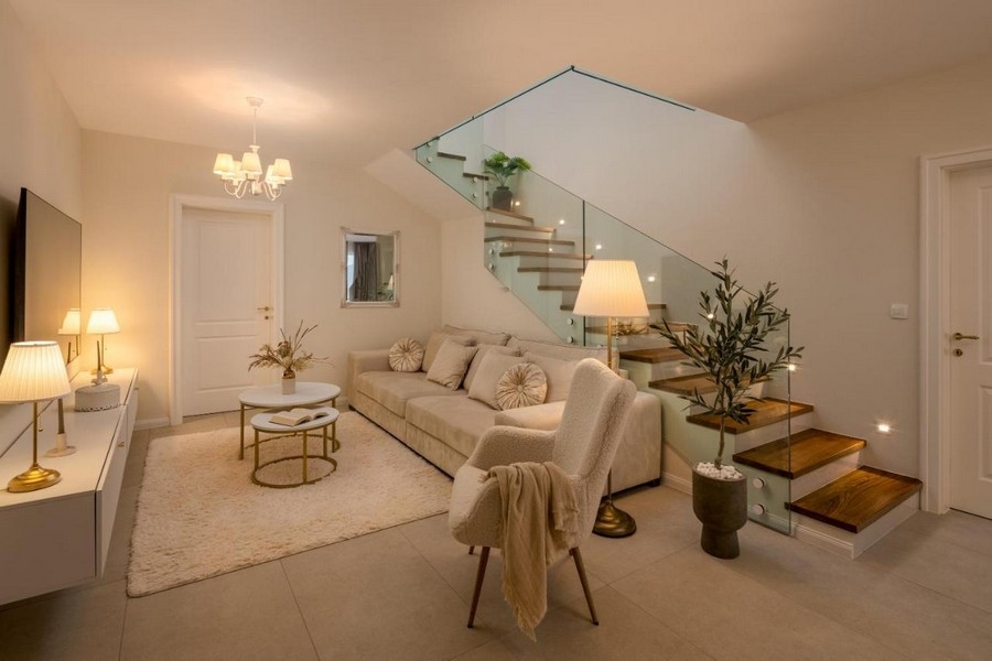 Obývacia časť s pohovkou a moderným schodiskom