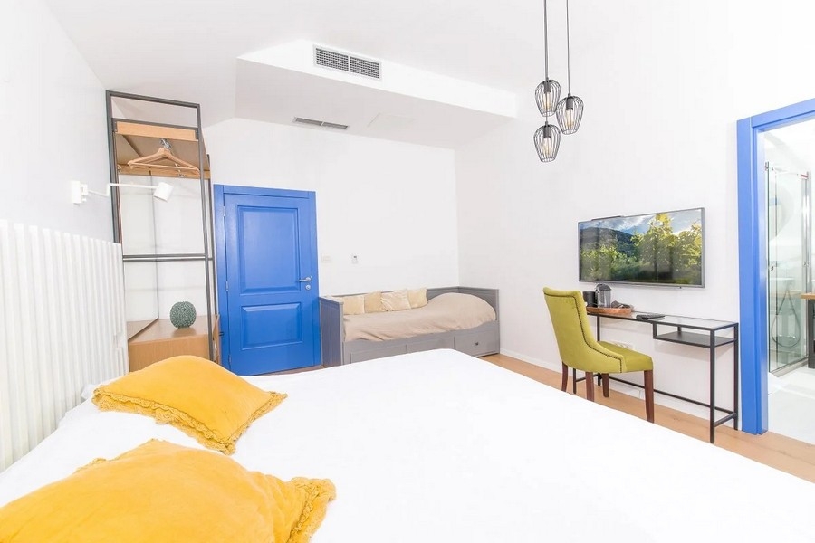 Spálňa s manželskou posteľou, písacím stolom a TV