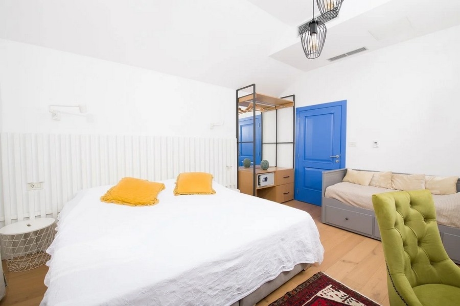 Spálňa s manželskou posteľou, modrými dverami a šatníkovou skriňou