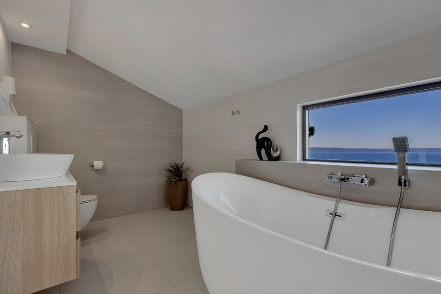 Moderná kúpeľňa s voľne stojacou vaňou a výhľadom na more