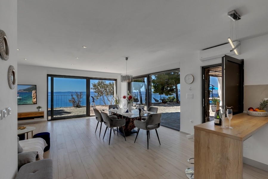 Obývacia izba s veľkým oknom a výhľadom na more