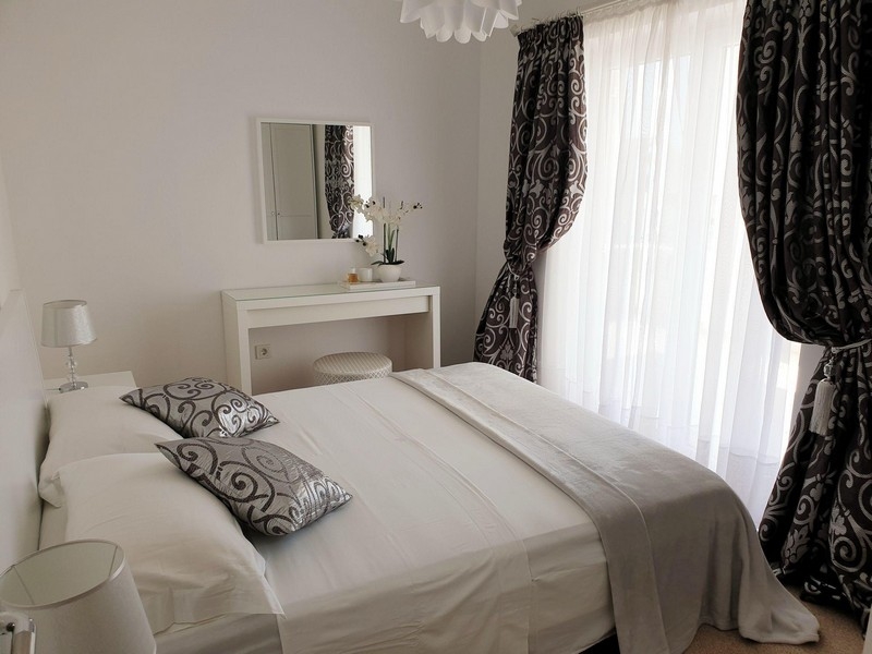 Spálňa s manželskou posteľou a oknom od podlahy až po strop