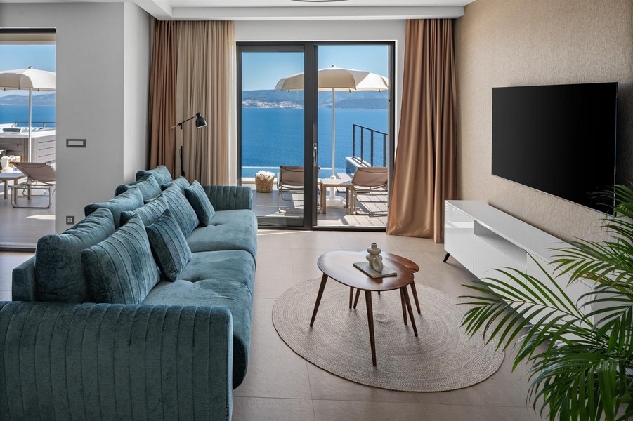 Obývacia izba s pohovkou a výhľadom na more cez panoramatické okná