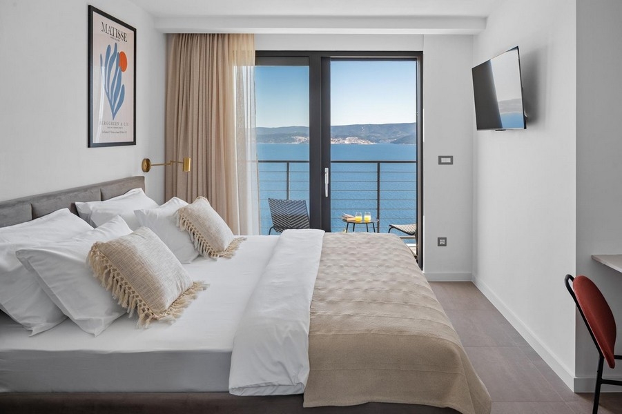 Spálňa s manželskou posteľou, balkónom a výhľadom na more