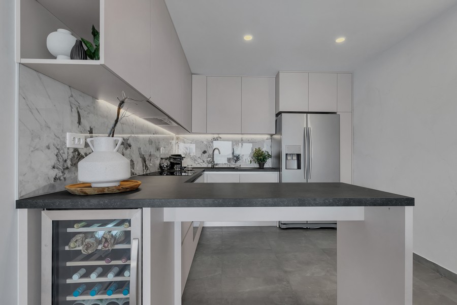 Moderne vybavená kuchyňa s ostrovčekom a chladničkou na víno