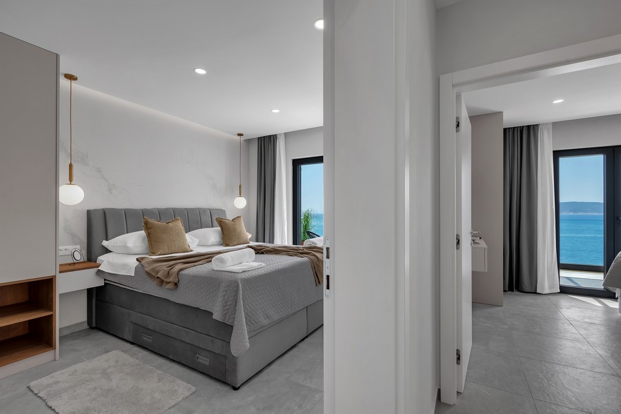 Spálňa s manželskou posteľou a balkónom s výhľadom na more