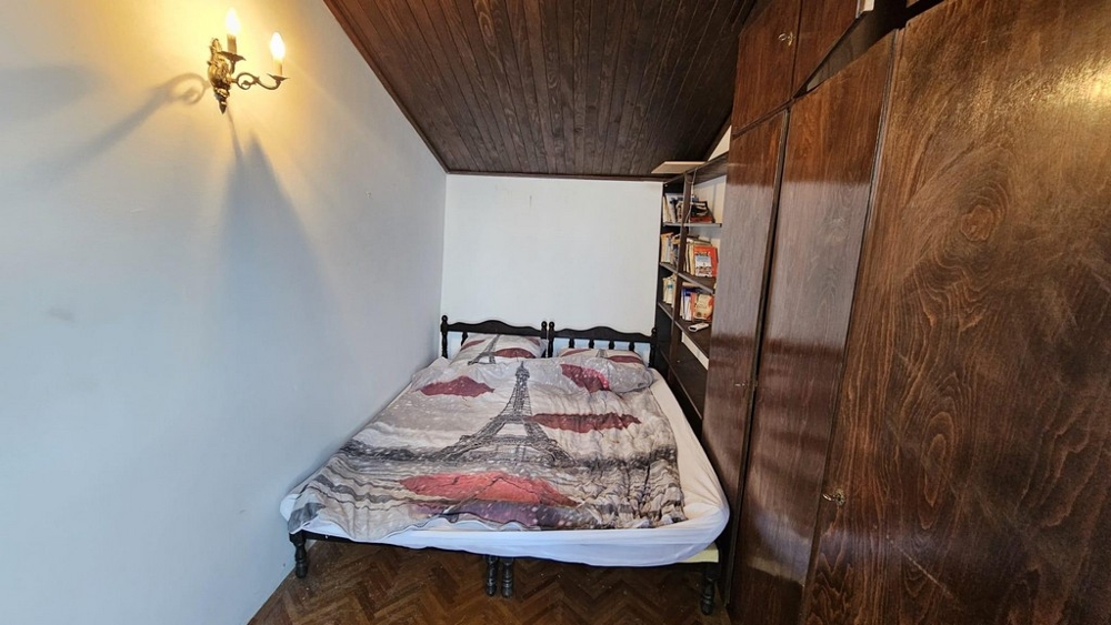 Spálňa s manželskou posteľou a dreveným stropom