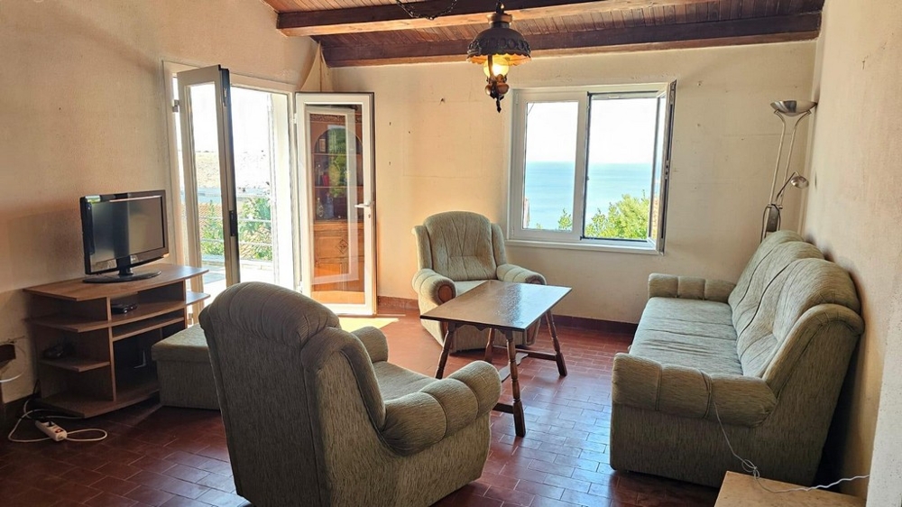 Obývacia izba s prístupom na terasu a výhľadom na more