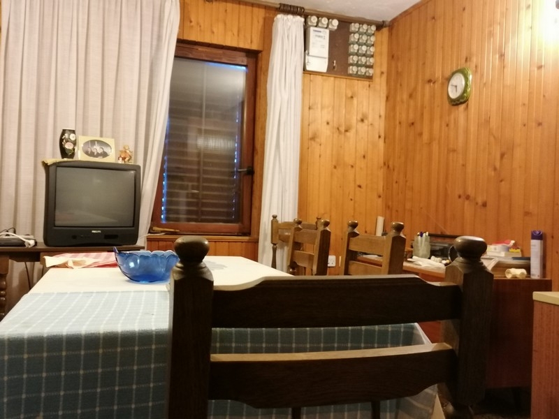 Jedáleň s drevenými stenami a TV