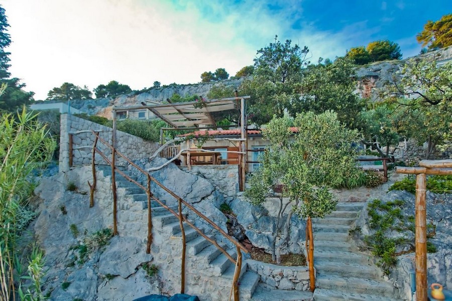 Kamenné schody do domu na svahu s krytou terasou