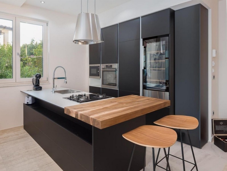 Moderná čierna kuchyňa s ostrovčekom a dreveným pultom