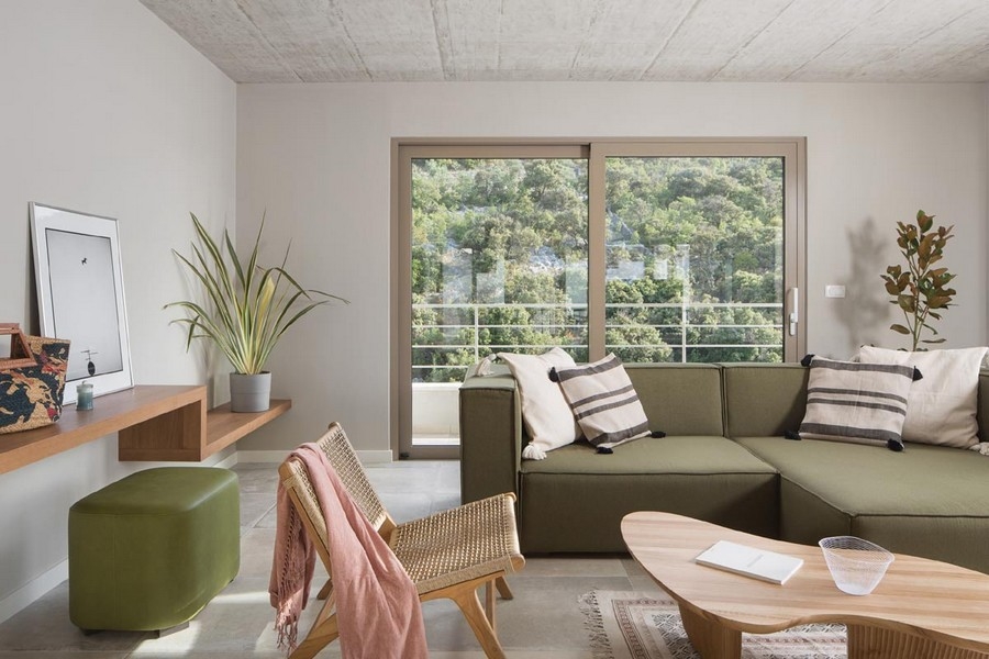 Moderne zariadená obývacia izba s pohovkou a veľkými oknami