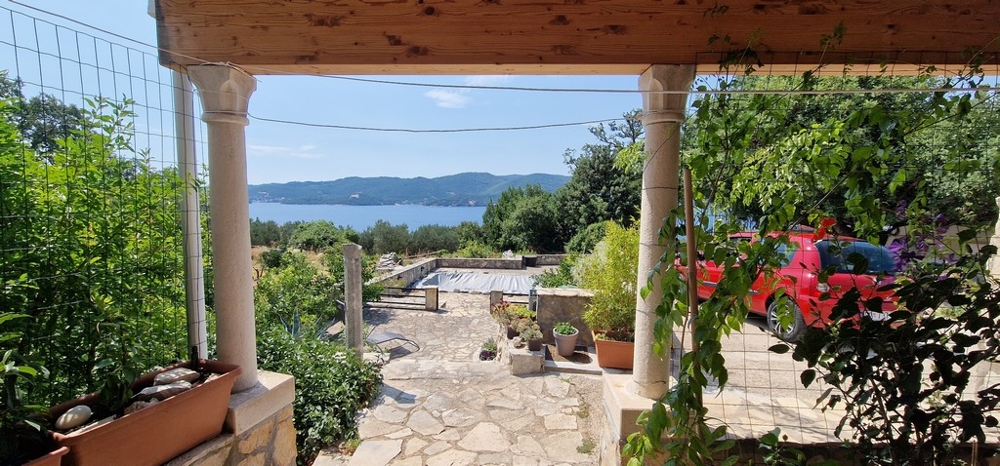 Krytá terasa s výhľadom na krytý bazén a more.