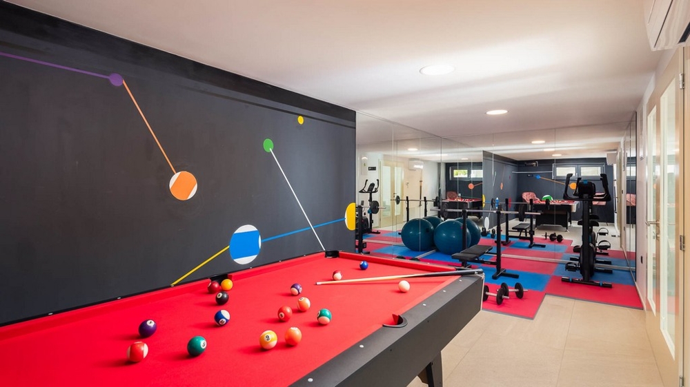 Voľnočasová a fitnes miestnosť s biliardom a cvičebným zariadením
