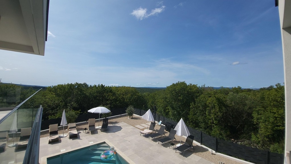 Pohľad na bazén s ležadlami a slnečníkmi