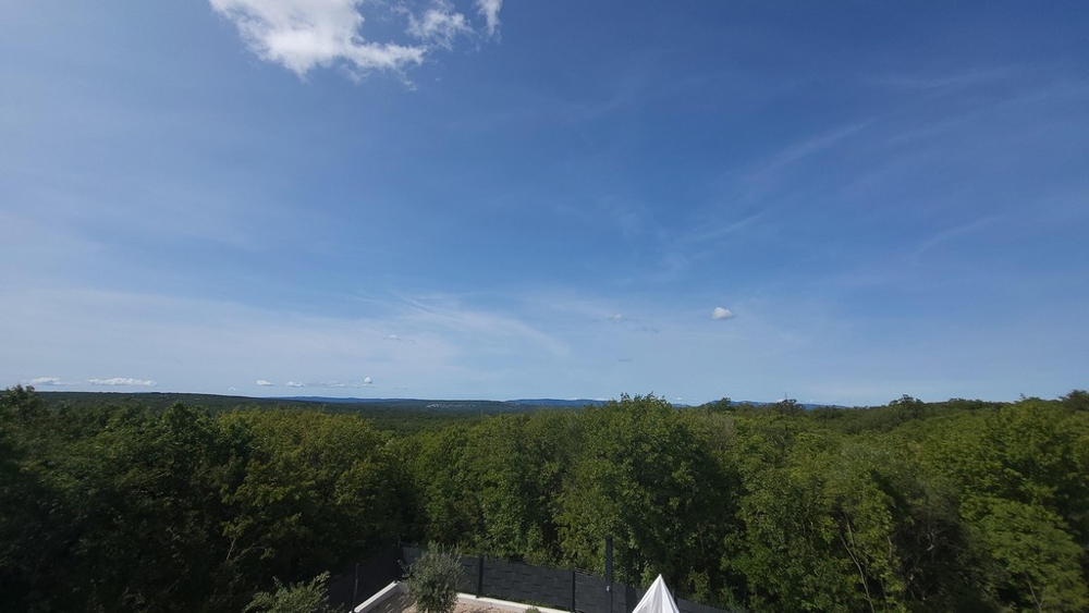 Pohľad na zelenú krajinu a more v pozadí