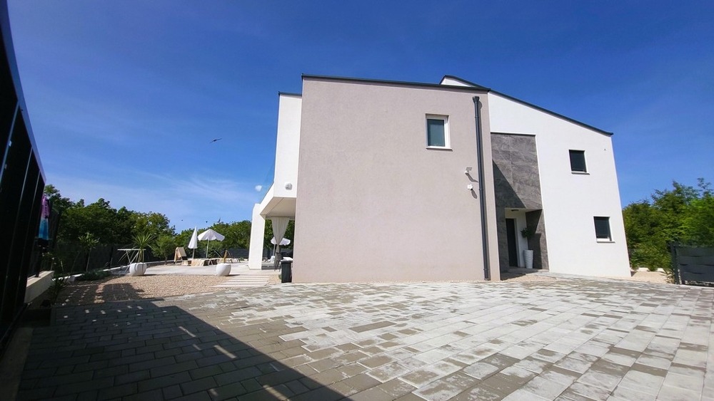 Bočný pohľad na dom s vydláždenou príjazdovou cestou