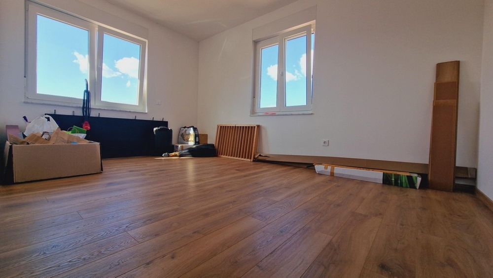 Spálňa s parketovými podlahami a veľkými oknami