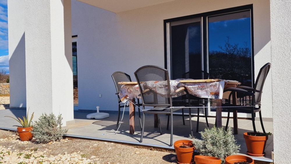 Krytá terasa so stolom a stoličkami v záhrade