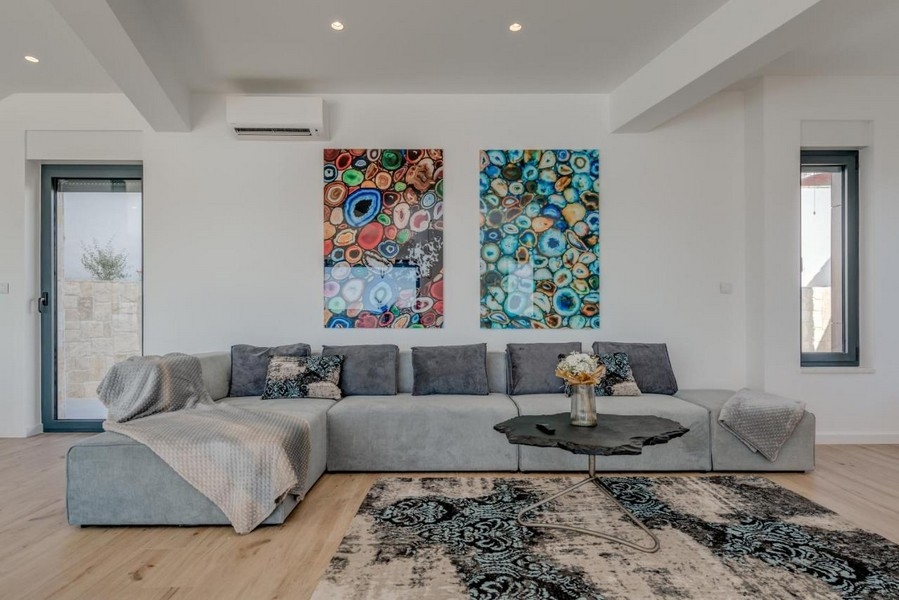 Moderná obývacia izba s veľkou pohovkou a nástennými maľbami