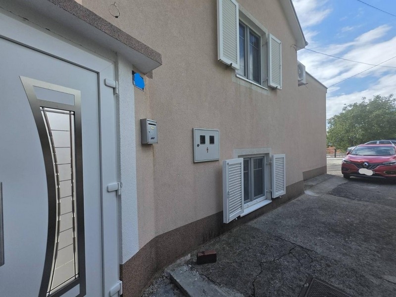 Fasáda domu so vstupnými dverami, žalúziami a parkovacím miestom