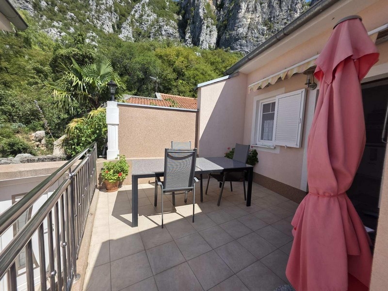 Terasa so stolom, stoličkami a výhľadom na skaly