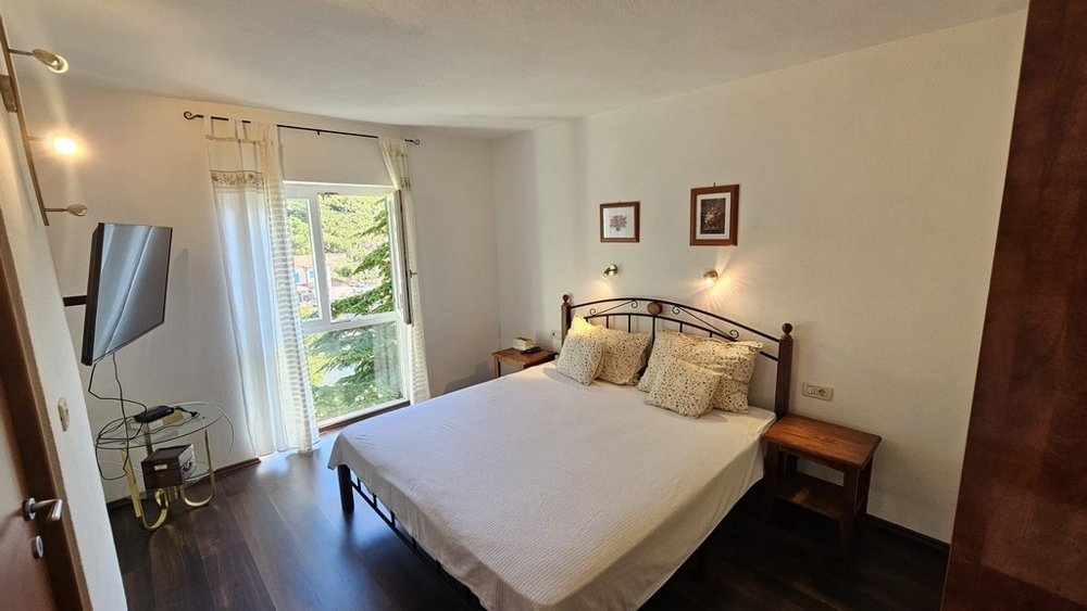 Spálňa s manželskou posteľou a výhľadom do zelene