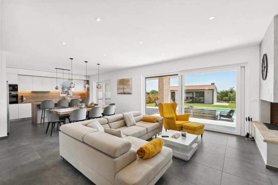 Svetlá obývacia izba s prístupom na terasu a výhľadom na bazén