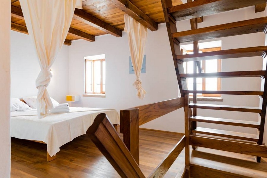 Spálňa s drevenými podlahami, schodmi a prirodzeným svetlom