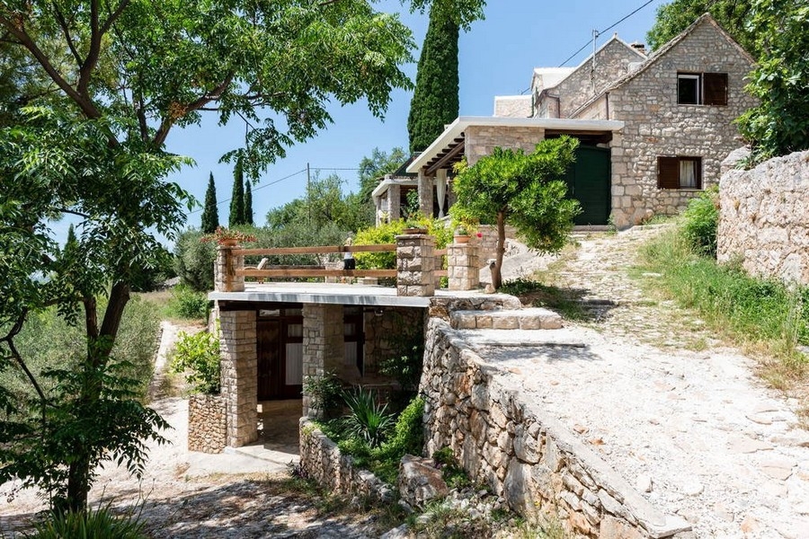 Kamenný dom na svahu so záhradou a terasou