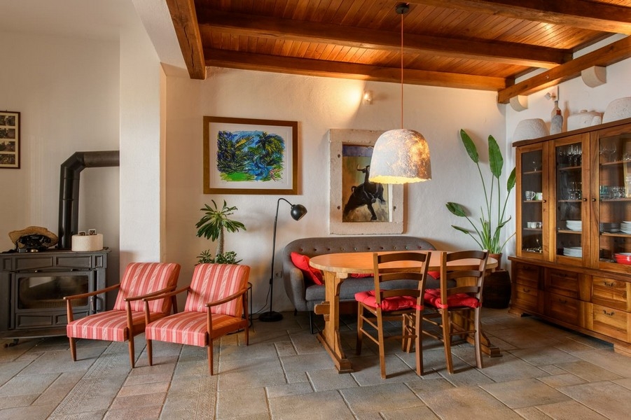 Obývacia izba s drevenými trámami, krbom a posedením