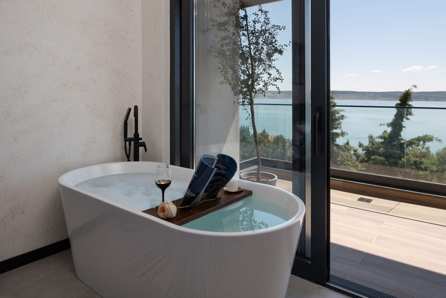Voľne stojaca vaňa pri okne s výhľadom na more