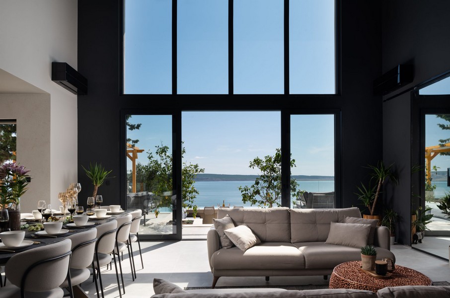 Obývacia izba s veľkými panoramatickými oknami a výhľadom na more