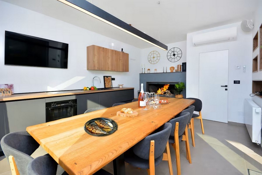 Jedálenský kút s veľkým dreveným stolom a vnútornými schodmi