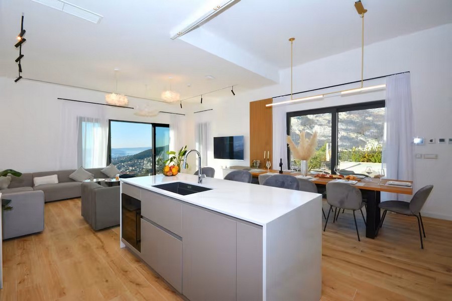 Otvorený obývací priestor s kuchyňou, jedálenským kútom a výhľadom na more