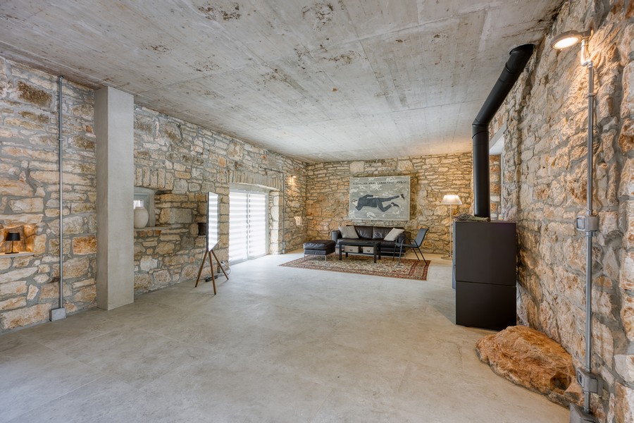 Priestranný obývací priestor s kamennými stenami a krbom