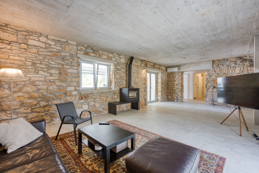 Obývacia izba s krbom a stenami z prírodného kameňa