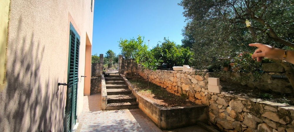 Vonkajšie schodisko s kamenným múrom a vstupom do domu