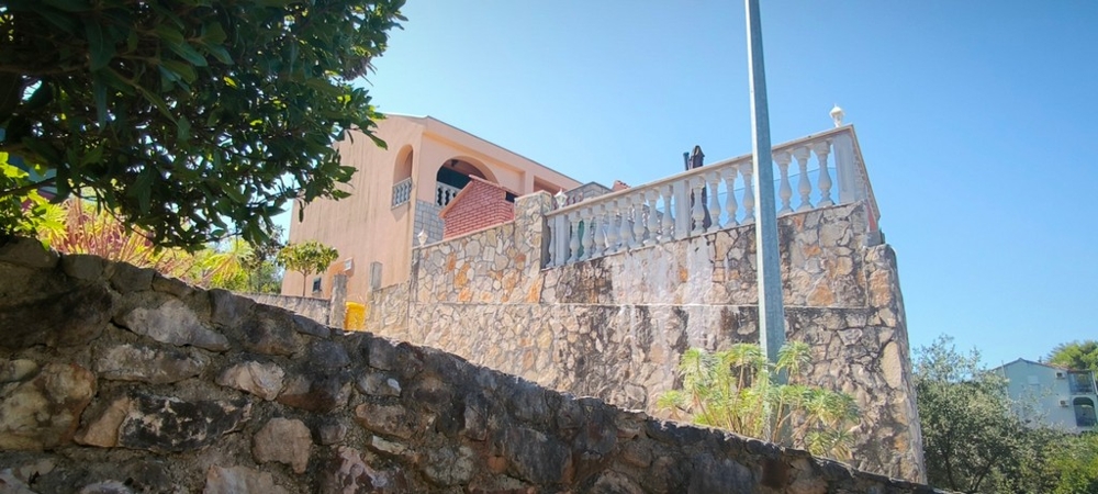 Dom na zvýšenom kamennom múre s terasou