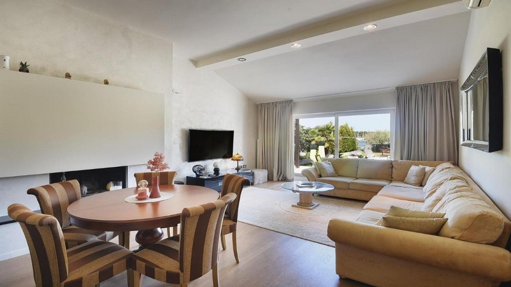 Obývacia izba s veľkým oknom a výhľadom do záhrady