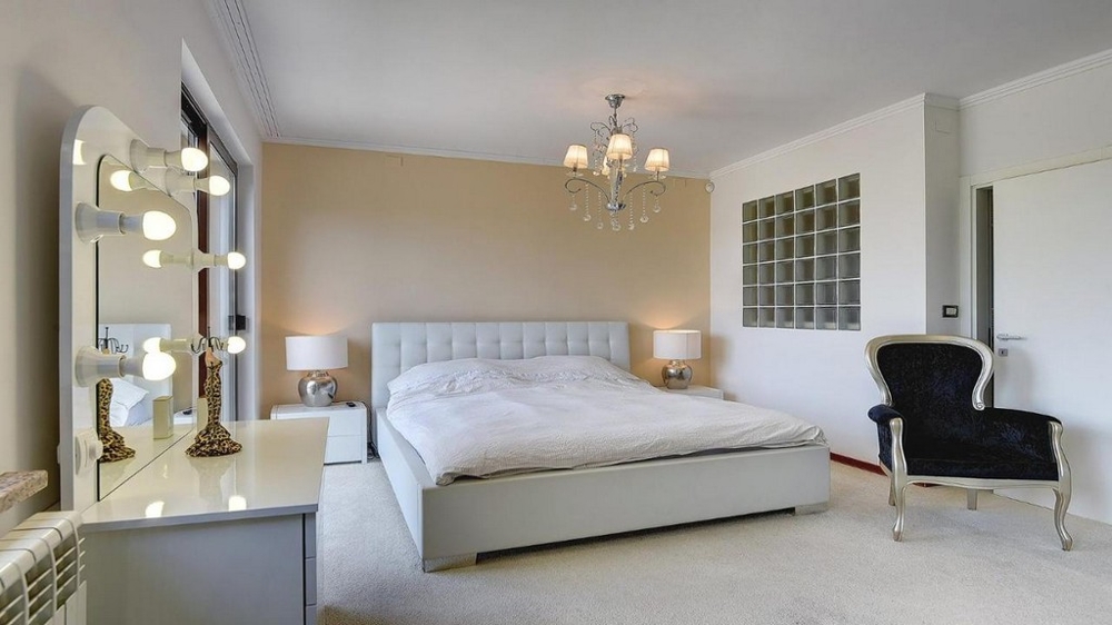 Spálňa s manželskou posteľou, toaletným stolíkom a lustrom