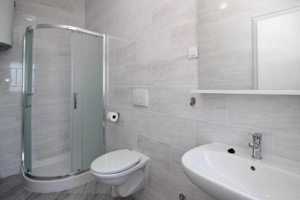 Moderná kúpeľňa so sprchovacím kútom a WC