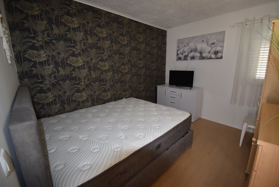 Spálňa s manželskou posteľou a TV