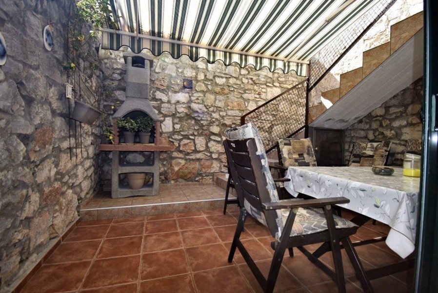 Krytá terasa s kamenným grilom a posedením