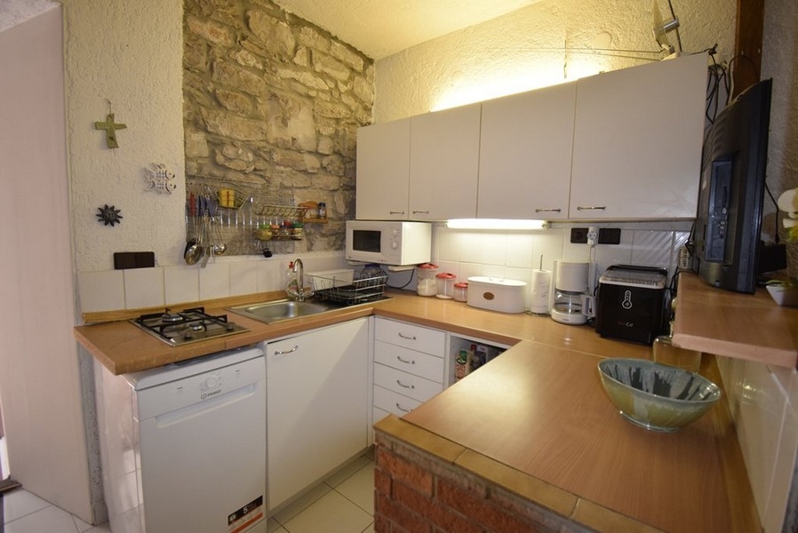 Kuchyňa s vybavenou kuchynkou a kamennou stenou