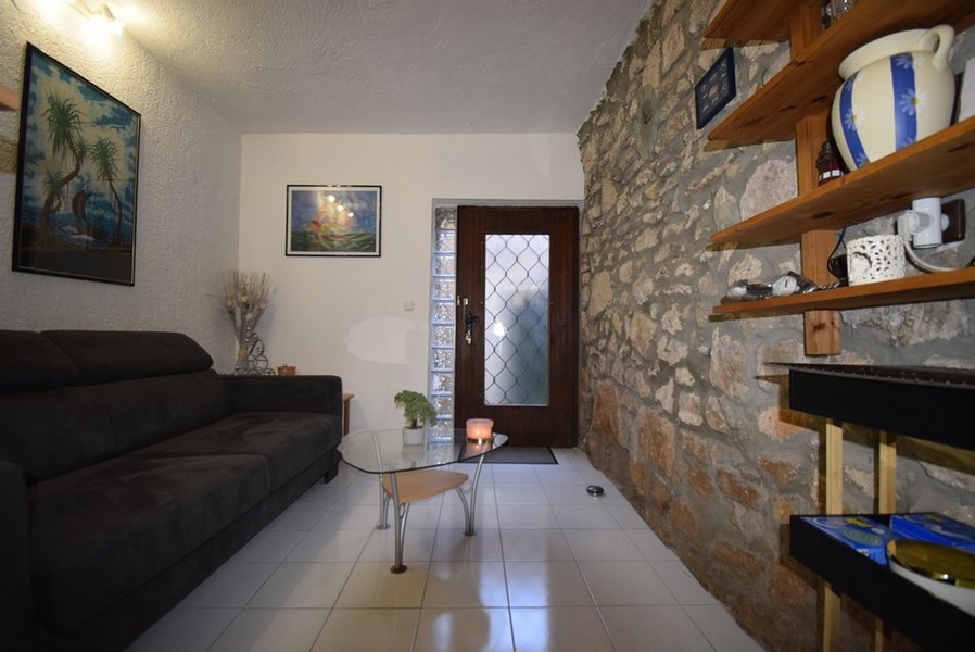 Obývacia izba s kamennou stenou a pohovkou