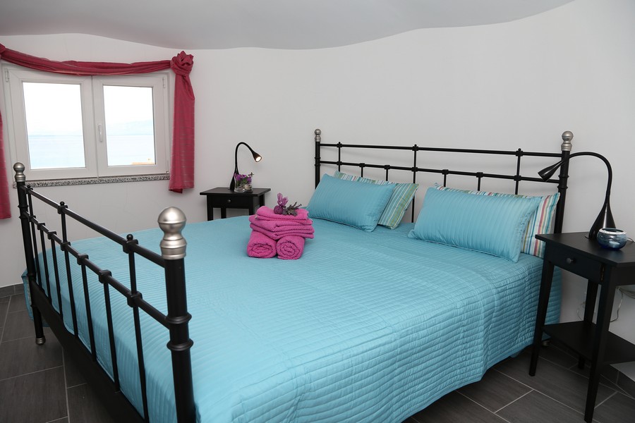 Spálňa s manželskou posteľou a výhľadom na more