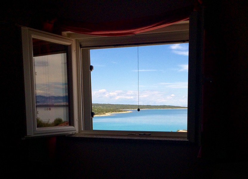 Pohľad cez okno na pobrežie a more