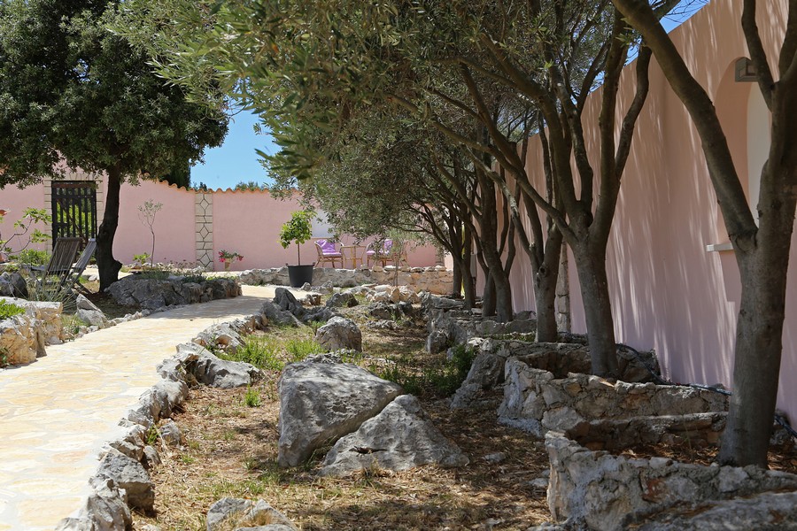 Záhradný chodník so stromami a prírodnými kameňmi vedľa domu